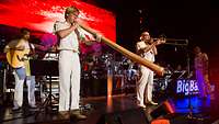 Soldat spielt ein australisches Didgeridoo, ein anderer Soldat spielt Posaune