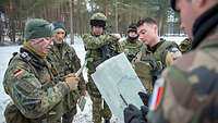 Soldaten unterschiedlicher Nationen besprechen sich im Wald