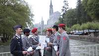 Soldaten mit Kerzen auf einer Brücke vor der Lichterprozession in Lourdes