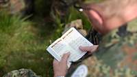 Soldat mit einem Gesangbuch bei der Messe auf dem Pic du Jer in Lourdes
