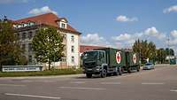 Ein großes Gebäude mit dem Schild davor Sachsen-Anhalt-Kaserne und einem Sanitäts-Militär-Lkw auf der Straße